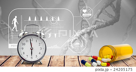 Alarm clock and pills put on a desk 24205175