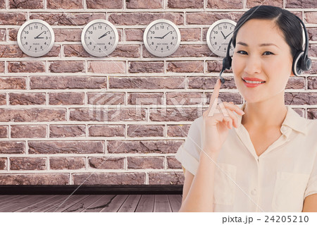 Composite image of beautiful smiling female executive with headset 24205210