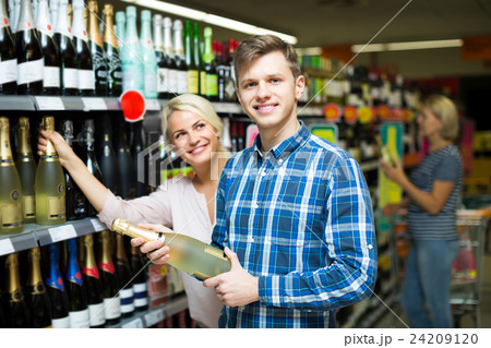 Family choosing wine at food shop 24209120