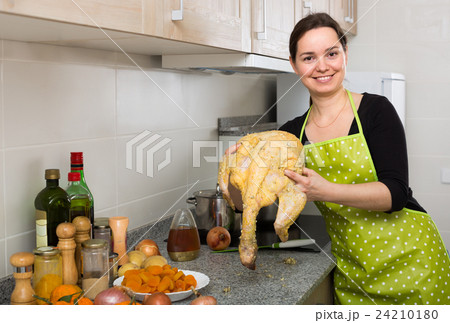 Woman preparing capon indoors . Woman preparing capon indoors . 24210180