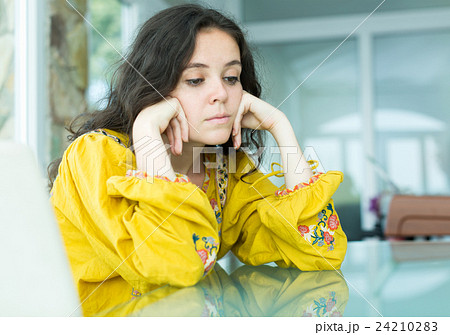 Girl sitting along at the table Girl sitting along at the table 24210283