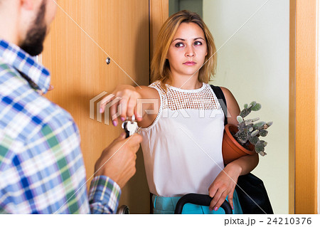 Frustrated couple standing at doorway 24210376