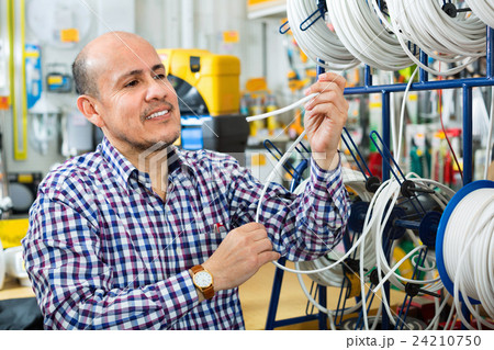 Mature male customer buying external cable Mature male customer buying external cable 24210750