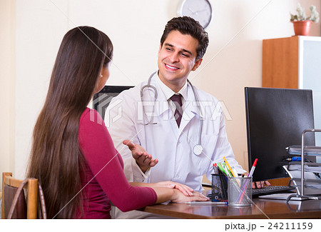 Patient and therapeutist at desk in clinic. 24211159