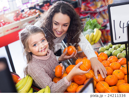 Mother and child purchasing mandarins 24211336