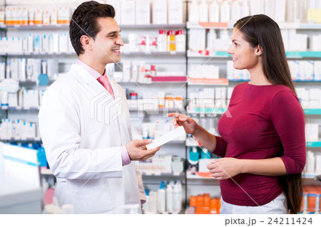Experienced pharmacist counseling female customer Experienced pharmacist counseling female customer 24211424