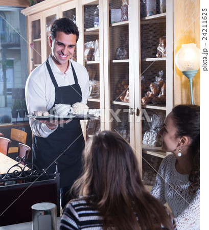 Girls and waiter in coffee-house . Girls and waiter in coffee-house . 24211625