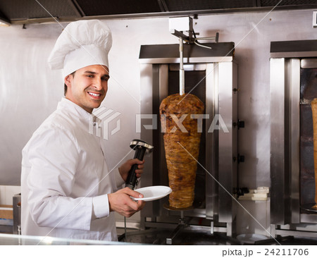 Adult arabian cook posing near meat for kebab 24211706