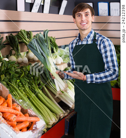 Grocery worker selling vegetables Grocery worker selling vegetables 24212398