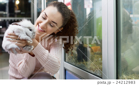 Portrait of smiling happy woman holding fluffy animal Portrait of smiling happy woman holding fluffy animal 24212983