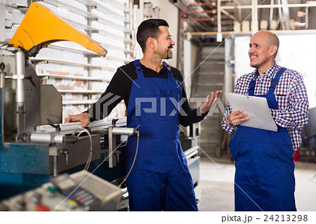 Two workmen near cutter-lathe machine. Two workmen near cutter-lathe machine. 24213298