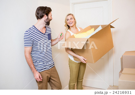 Couple holding a carton in their new house Couple holding a carton in their new house 24216931