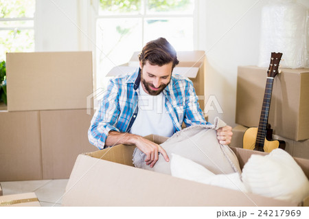 Young man unpacking carton boxes 24217969
