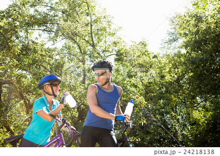 Senior couple standing with their bikes Senior couple standing with their bikes 24218138