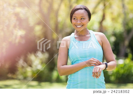 Happy woman posing and touching her watch Happy woman posing and touching her watch 24218302