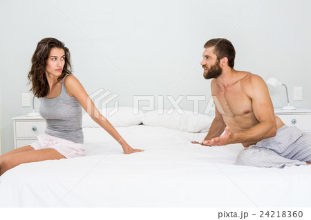 Man arguing with woman on bed 24218360