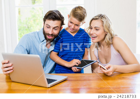 Parents and son using a laptop, tablet and phone Parents and son using a laptop, tablet and phone 24218733
