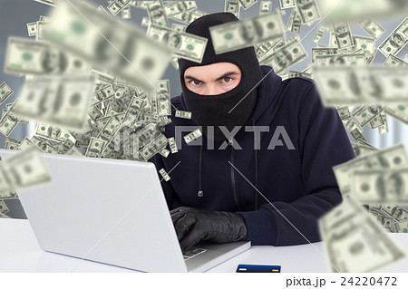 Composite image of hacker in balaclava hacking a laptop Composite image of hacker in balaclava hacking a laptop 24220472