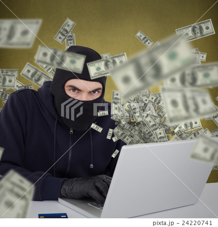 Composite image of hacker in balaclava hacking a laptop Composite image of hacker in balaclava hacking a laptop 24220741
