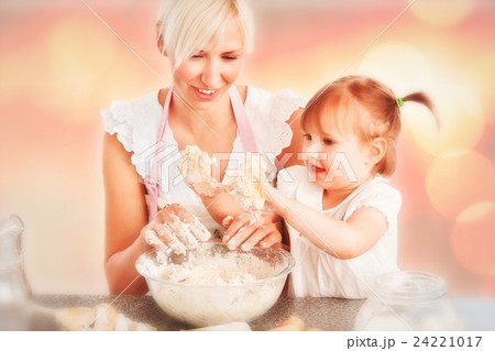 Composite image of simper woman baking cookies with her daughter Composite image of simper woman baking cookies with her daughter 24221017