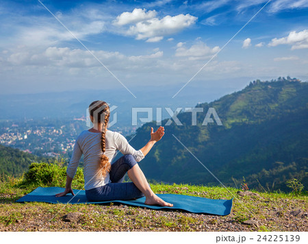Woman practices yoga asana outdoors 24225139