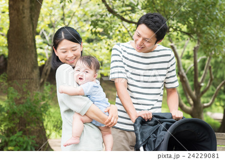 公園で散歩する赤ちゃんと両親 24229081