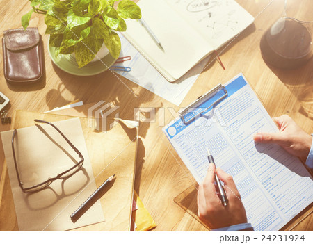 Businessman Filling Up Form on Office Desk Concept Businessman Filling Up Form on Office Desk Concept 24231924