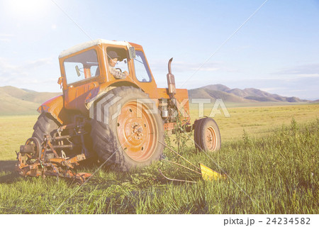 Mongolian Farmer Driving His Tractor On The Field Mongolian Farmer Driving His Tractor On The Field 24234582