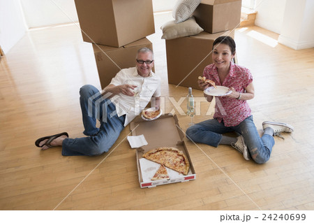Couple eating pizza in new apartment Couple eating pizza in new apartment 24240699