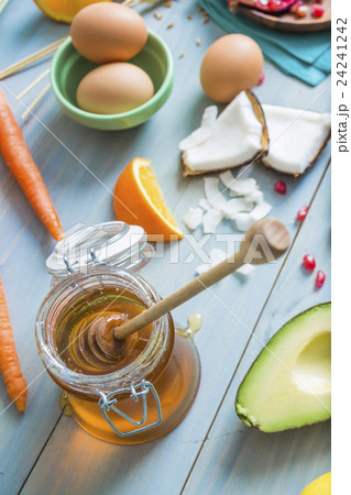Jar of honey with dipper and fresh ingredients 24241242