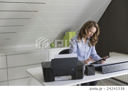 Mid-adult woman working with tablet in office 24241536