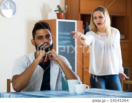 Blonde girl yelling at black boyfriend as quarreling indoors 24245264