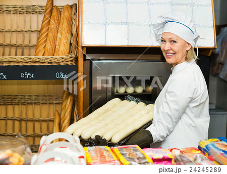 Portrait of mature female baking baguettes Portrait of mature female baking baguettes 24245289