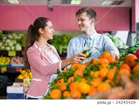 Beautiful brunette girl and boyfriend buying citruses Beautiful brunette girl and boyfriend buying citruses 24245429