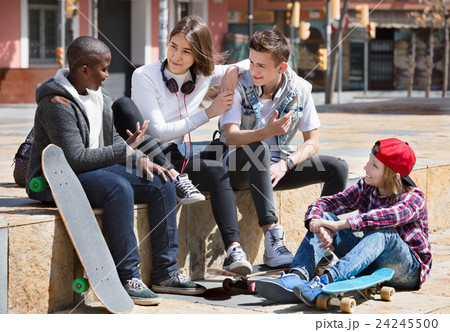 Group of teenage friends relaxing and chatting Group of teenage friends relaxing and chatting 24245500