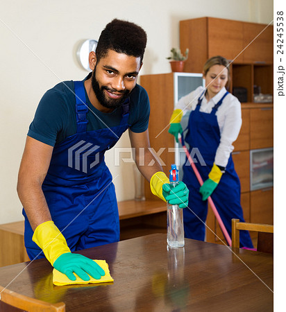 professional couple in uniform cleaning at domestic interior professional couple in uniform cleaning at domestic interior 24245538