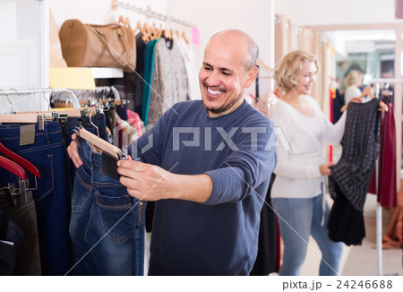 spouses buying pair of classic jeans in boutique spouses buying pair of classic jeans in boutique 24246688