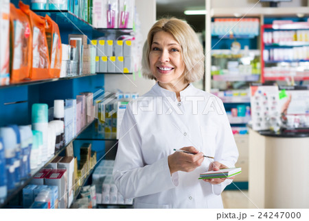female pharmacist posing in drugstore female pharmacist posing in drugstore 24247000