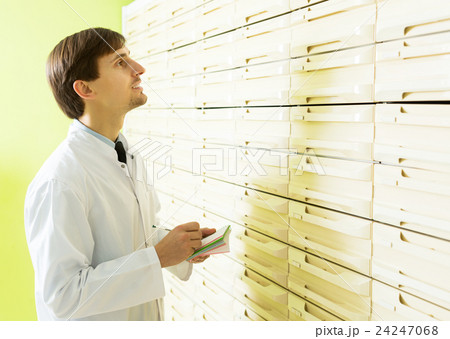 Pharmacist posing in pharmacy depot Pharmacist posing in pharmacy depot 24247068