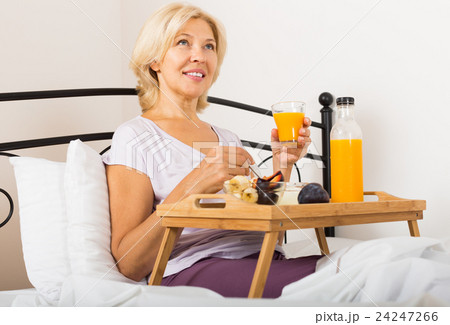 Mature woman enjoying healthy breakfast Mature woman enjoying healthy breakfast 24247266