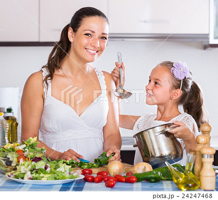 woman and little girl cooking vegetables 24247468