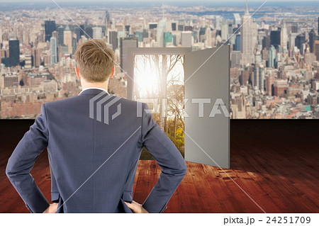 Composite image of rear view of businessman standing with hands on wiast 24251709