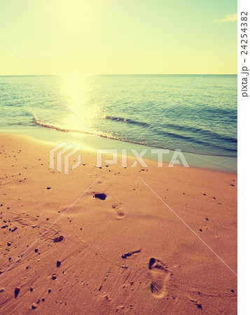 Footprints in sand. Traces on beach by smooth sea Footprints in sand. Traces on beach by smooth sea 24254382