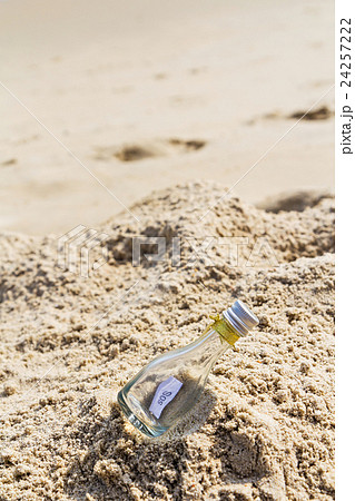 SOS message in glass bottle on the beach. SOS message in glass bottle on the beach. 24257222