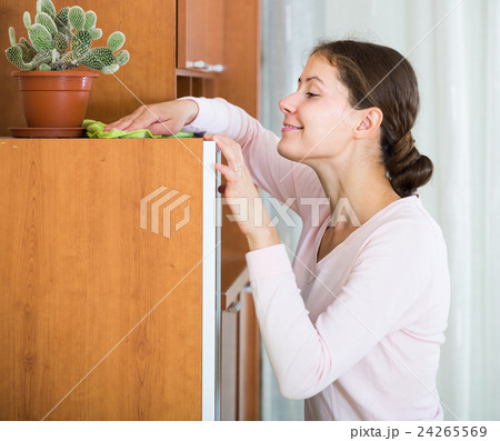 housewife doing regular clean up in living room 24265569
