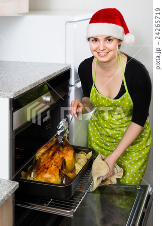 housewife in Santa hat baking festive capon housewife in Santa hat baking festive capon 24265719