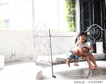 ソファーでひざまくらをする姉弟 24265867