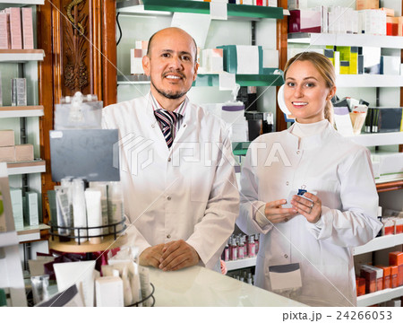 Female and male pharmacists working the pharmaceutical store Female and male pharmacists working the pharmaceutical store 24266053