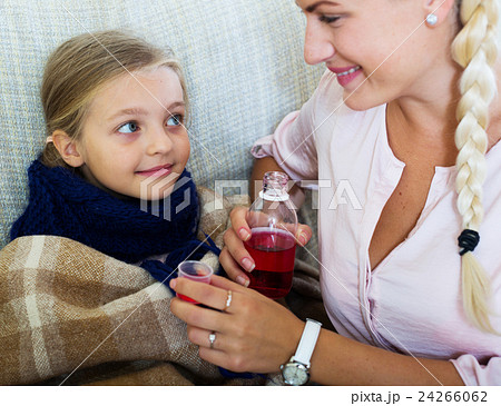 Stressed woman giving liquid medicine to little girl with grippe 24266062