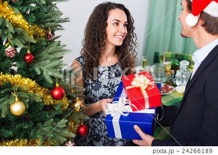 Beautiful woman giving present to man in Christmas dinner Beautiful woman giving present to man in Christmas dinner 24266189